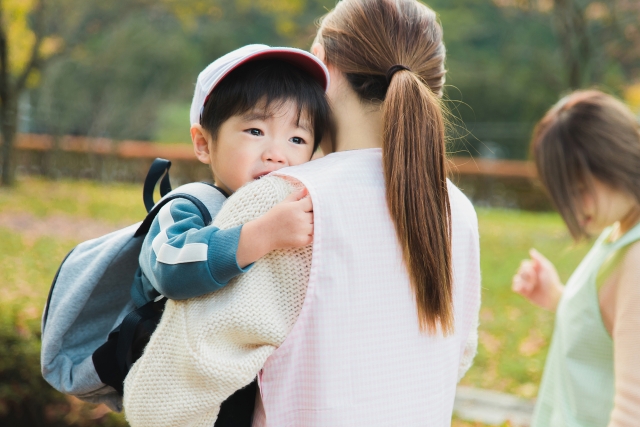 子どもを女性スタッフが抱きかかえる